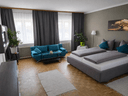 Suite Lebensbaum – Wohnbereich mit türkisem Sofa und Doppelbett