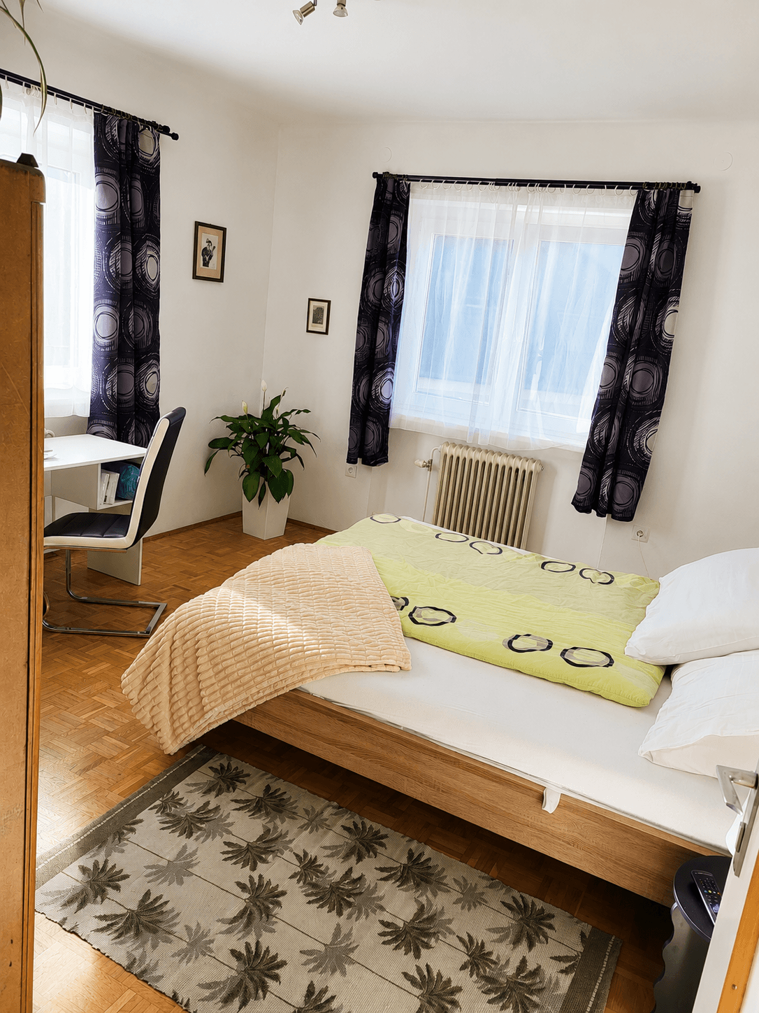 Das Sonnenzimmer – Blick auf Bett, Schreibtisch und helle Fenster